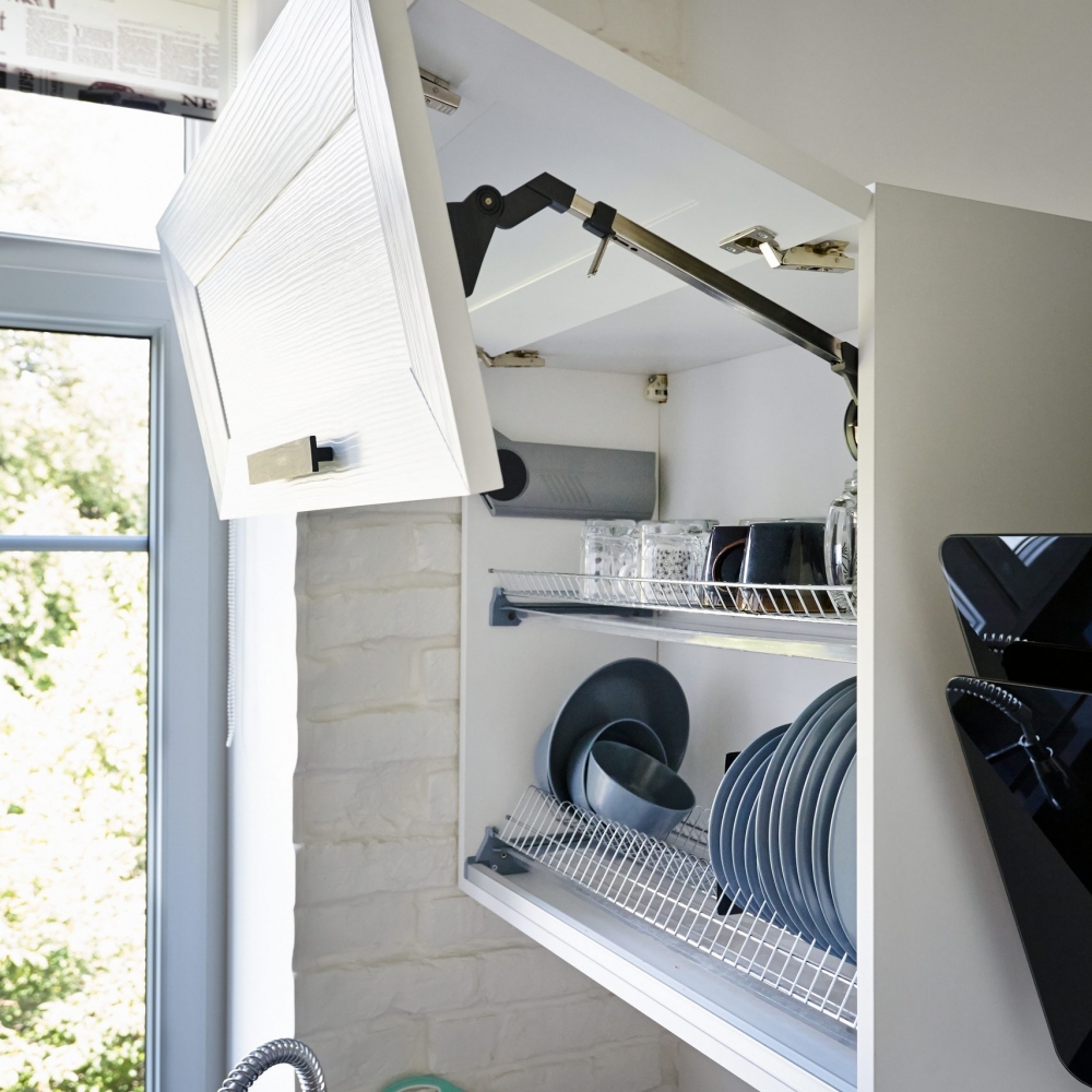 Completely Opened White Kitchen Cabinet with Plates on Shelf
