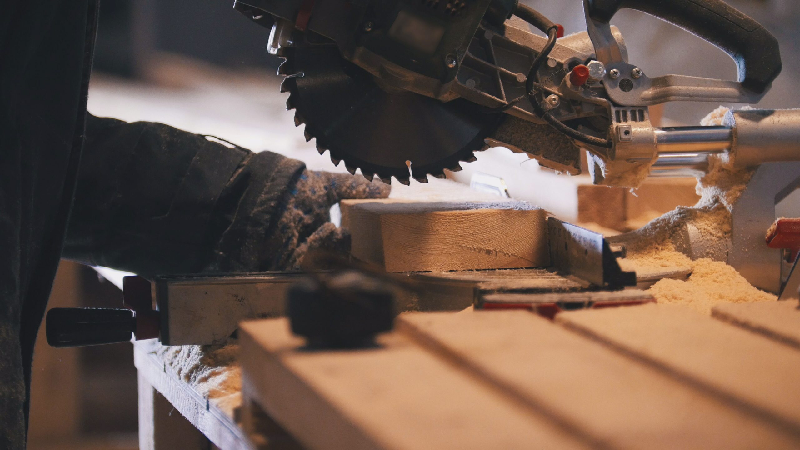 Worker carpenter figuring wooden board before circular saw sawing, close up
